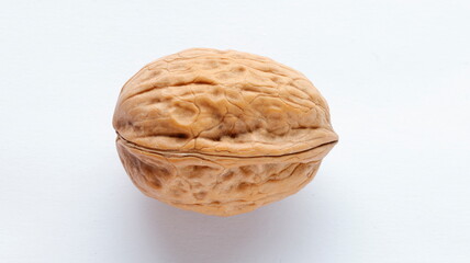 close up big brown raw walnut nut isolated on white background, nuts with hard shell. top view