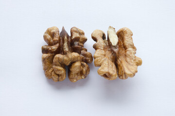 close up of half brown raw walnut cracked nuts, a splintered walnuts isolated on white background. set on upside down and front. top view