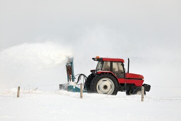 Red Tractor Snow Blowing a Driveway in a Rural Setting