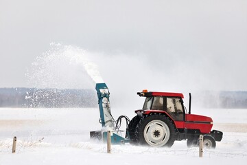 Red Tractor Snow Blowing a Driveway in a Rural Setting