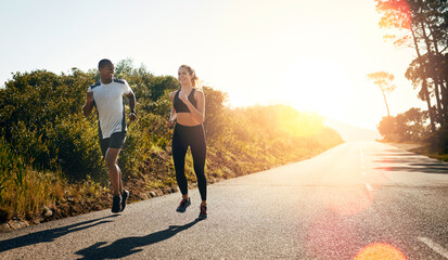 Taking their run out on the open road. Shot of a fit young couple going for a run outdoors.
