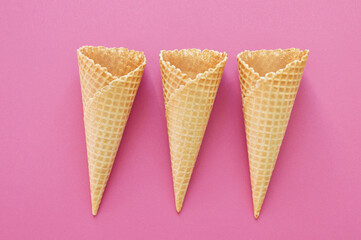three waffle cones on a raspberry background
