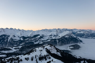 Obraz premium Amazing sunrise with red sky and a beautiful landscape in the wonderful region in Switzerland called Mythenregion. Beautiful mountain called Mythen and an epic sea of fog in the background.