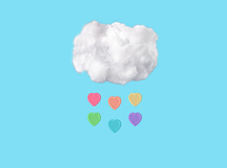 Cotton cloud and colorful heart raindrops at blue sky background in funny surreal style. Spring weather. High quality photo. LGBT concept