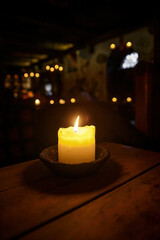 Candle on a table in a medieval tavern.