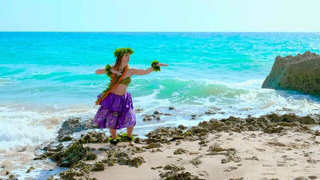 Pretty and smiling woman performing hawaiian dance on the beach. Hula dancer dancing hawaiian dance from hawai.