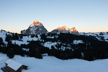 Amazing sunrise with red sky and a beautiful landscape in the wonderful region in Switzerland called Mythenregion. Beautiful mountain called Mythen and an epic sea of fog in the background.