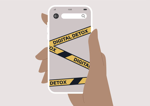 Digital detox concept, a hand holding a mobile phone with a yellow tape on the screen