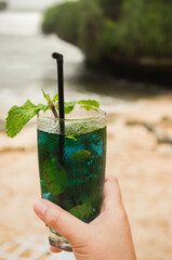 Person hand holding a glass of cold drinks