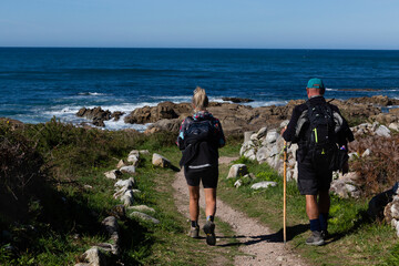 Two pilgrims walk the Portuguese Camino de Santiago along the coast in A Guarda © casavella