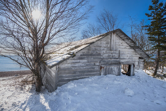 Old Fishing Shack Along Shore of Lake Superior Winter Into the Sun