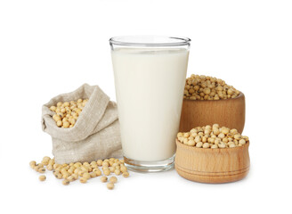 Glass of fresh soy milk and beans on white background