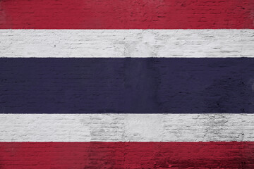 Full frame photo of a weathered flag of Thailand painted on a plastered brick wall.