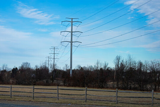 High voltage electrical power towers and cables against a blue sky on a partly cloudy day  -03