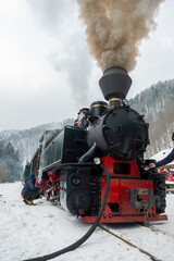 Obraz na płótnie Canvas Steam train Mocanita on a railway station in winter, Romania