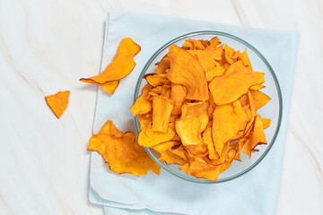 Bowl with yummy sweet potato chips on table