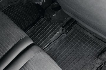 Black rubber car floor carpet in auto, above view