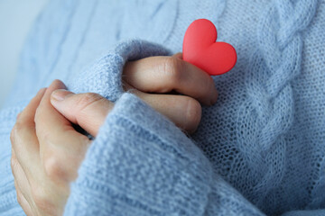 Red heart in female hands close up. The concept of health, love and charity.