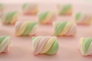 Colorful marshmallows composition on a pink background - copy space