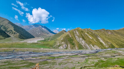 Obraz premium The Terek (Tergi) river flows down the Truso Valley near the Ketrisi Village Kazbegi District,Mtskheta in the Greater Caucasus Mountains,Georgia.Ketrisi village and Zakagori Fortress in the distance