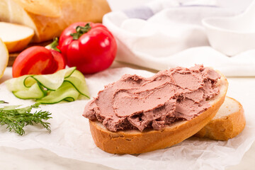 Liver meat pate spread on white bread, on a light background, breakfast, close-up, no people, selective focus,
