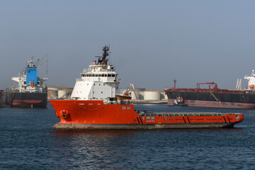 Big orange offshore supply vessel in the port. AHTS ship.
