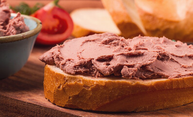 Liver meat pate spread on white bread, on a wooden background, breakfast, close-up, no people, selective focus,