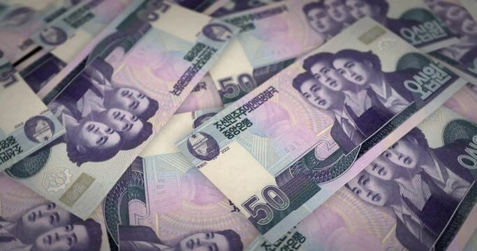 North Korea Won growing pile of money. KPW banknotes loop rotaring. Seamless and looped background concept of finance, economy crisis, inflation and business.
