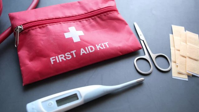 Close up of first aid kit and thermometer on black 