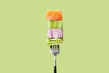 Close-up of fork with food on it: delicious fillet salmon, cucumber, onion, green salad on green background. Concept of healthy diet and clean eating, balanced nutrition space for text - obrazy, fototapety, plakaty