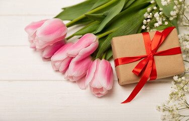 Pink tulips and gypsophila gift box on a white wooden background.Side view. Spring bouquet.Holiday concept.Women's day, Valentine's day,Easter, birthday.Copy space.