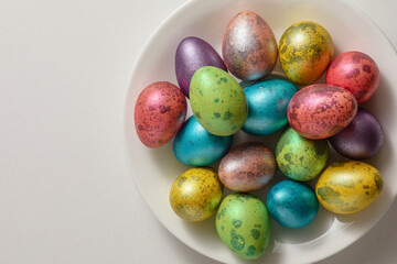 easter multicolored eggs on a white platter. the concept of celebrating Easter