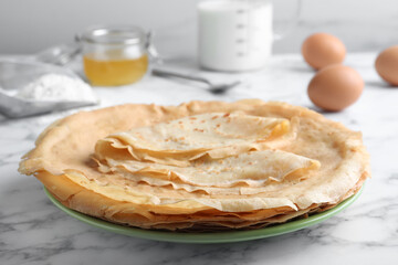 Delicious crepes on white marble table, closeup