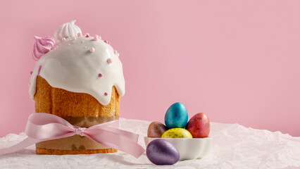 Easter cakes, traditional multi-colored eggs on the festive table, on a pink background