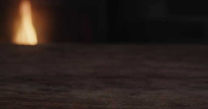 Male hand shakily picks up glass of near empty Bourbon, then places it back on counter