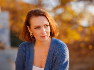 Portrait of beautiful young woman walking in an autumn park