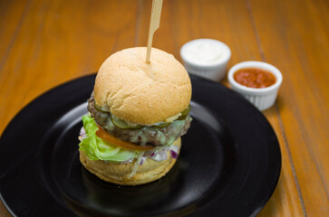 Close-up of tasty homemade hamburger on wooden table.