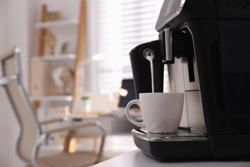 Modern coffee machine pouring milk into cup in office. Space for text