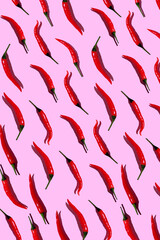 pattern of red hot chili peppers on a pink background. Top view. Flat lay. Wallpaper with fresh red hot chili peppers. Red chili peppers  on a pink background.