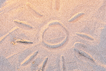Fototapeta na wymiar children's drawing on the sand on a summer day - the sun
