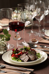Delicious grilled meat with vegetables and wine served on table in restaurant