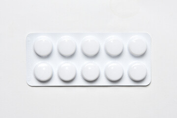 Pills in package top view on white background