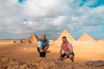 Two men travelers posing in front of the great pyramids of giza in cairo egypt. Traveling egypt...