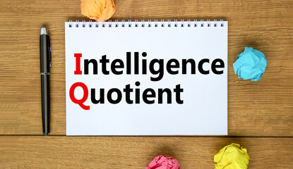 Naklejka premium IQ intelligence quotient symbol. Concept words IQ intelligence quotient on white note. Metallic pen. Beautiful wooden background. Business IQ intelligence quotient concept, copy space.