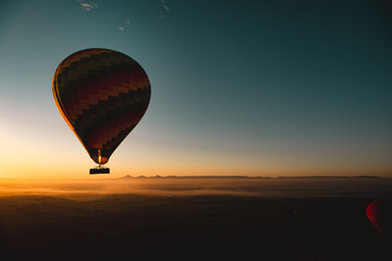 Amazing view of a vibrant colorful balloon at sunrise, flame firing to propel the balloon upwards. Balloon ride at luxor, egypt, famous in cappadocia