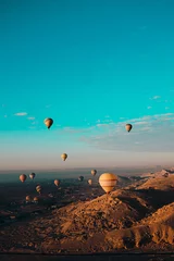 Foto op Plexiglas Amazing vertical shot of dozens of hot air balloons flying around the luxor egypt area. Desert orange area early in the morning. Bright blue sky © Antonio
