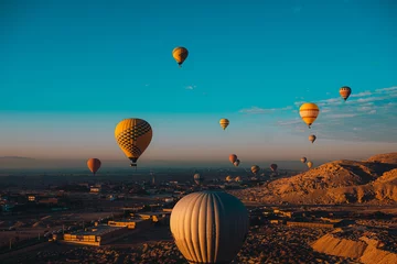Foto op Plexiglas Wide view of dozens of hot air balloons flying around the luxor egypt area. Popular tourist activity, amazing view of the surrounding desert area © Antonio
