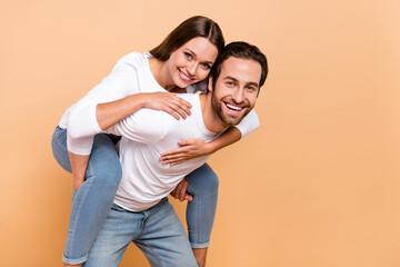 Photo of cute millennial brunette couple hug play wear shirt jeans isolated on beige background