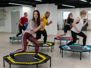 Women's and men's group on a sports trampoline, fitness training, healthy life - a concept...