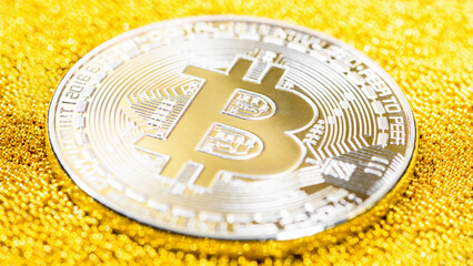 Silver bitcoin on yellow gold placer surface. Crypto currency. Bitcoin mining concept